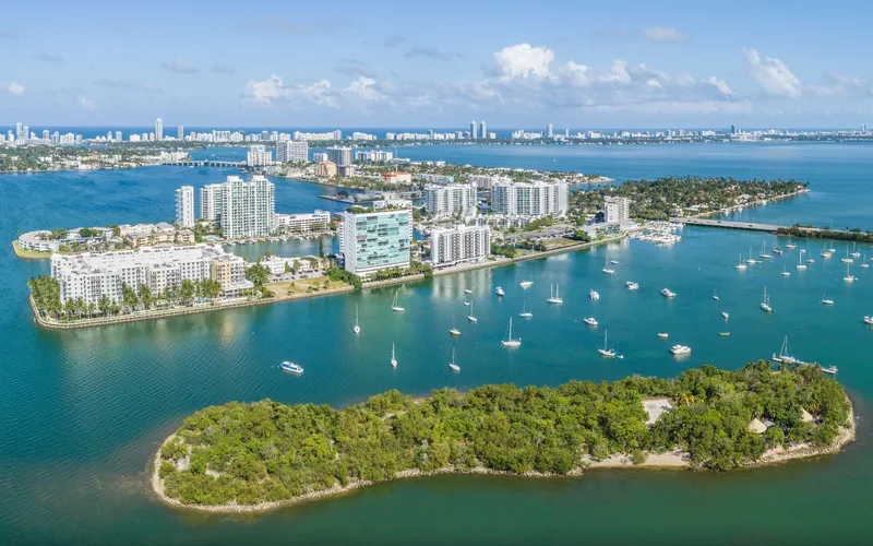 Aerial view of Harbor Island and its waterfront apartment buildings beyond a small wooded island