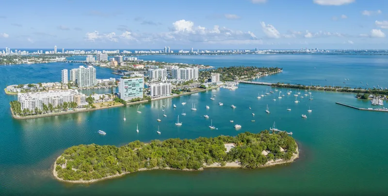 Aerial view across Biscayne Bay toward Harbor Island and North Bay Village, with a small wooded island in the foreground