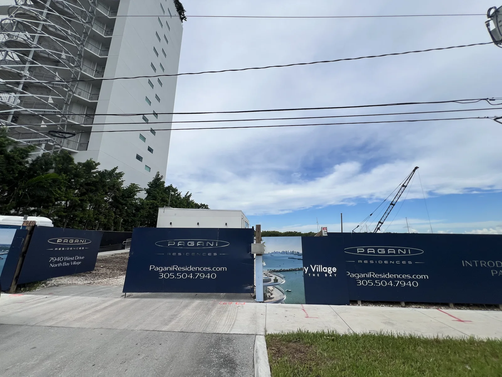 Pagani Residences fencing with the 7940 West Drive address, a crane behind it and a neighboring building