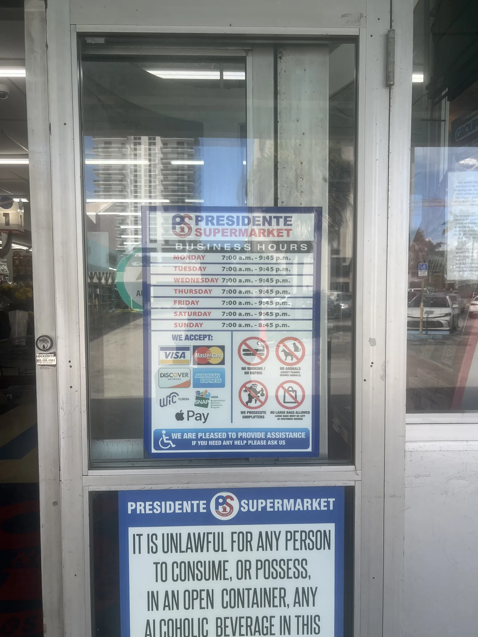 Business hours posted on the Presidente Supermarket entrance door in North Bay Village