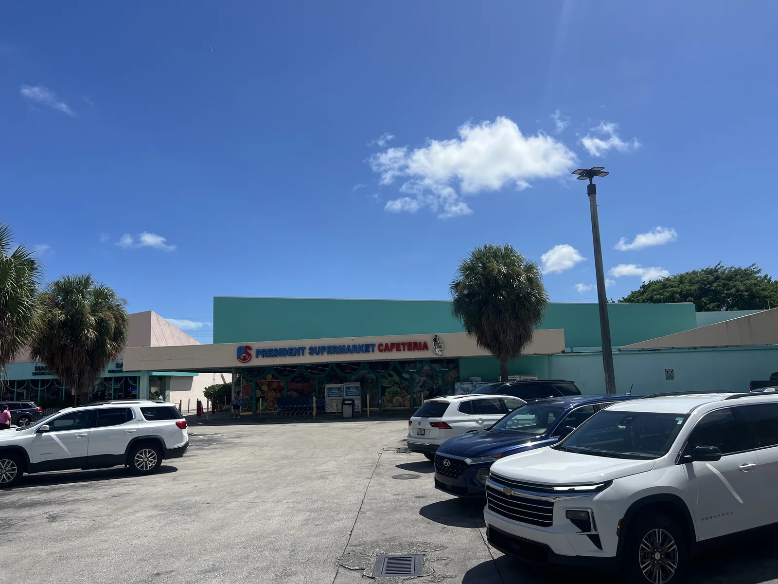 Presidente Supermarket and Cafeteria sign above the entrance, viewed across the parking area on Treasure Island