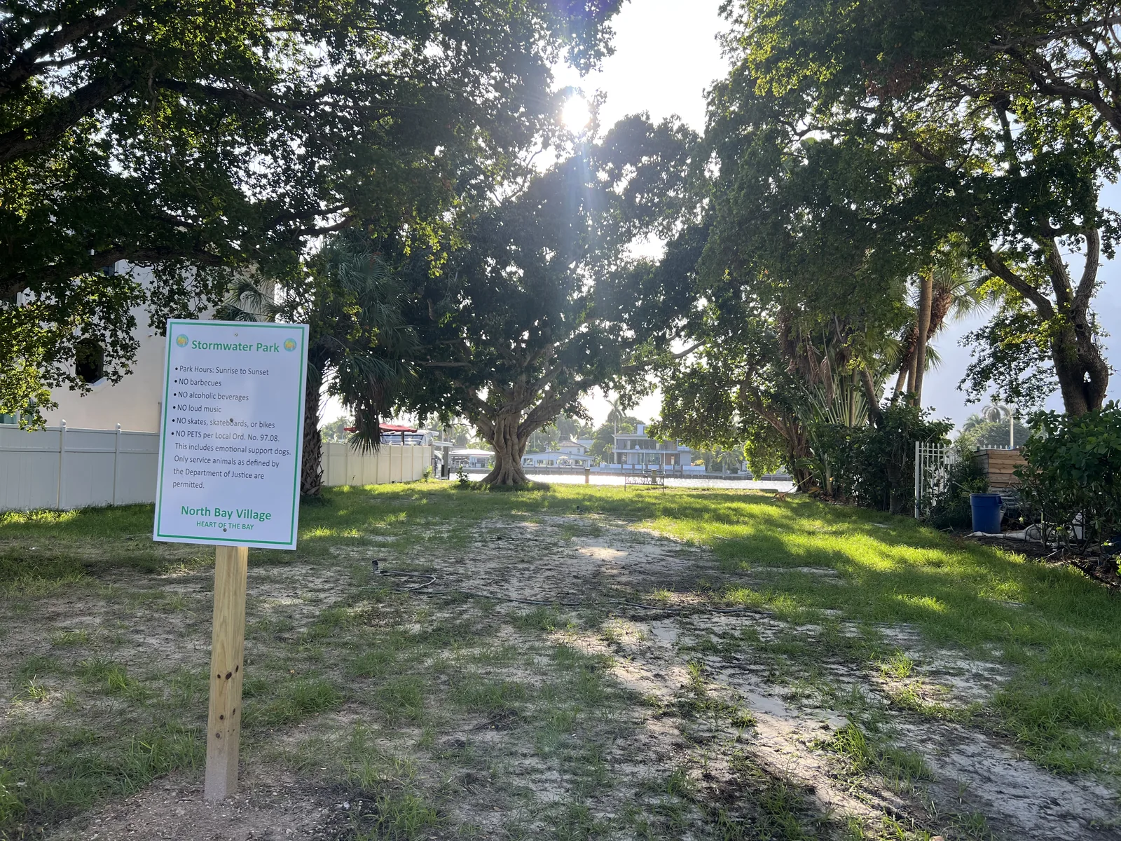 Stormwater Park entrance sign with posted hours and rules beside the shaded lawn