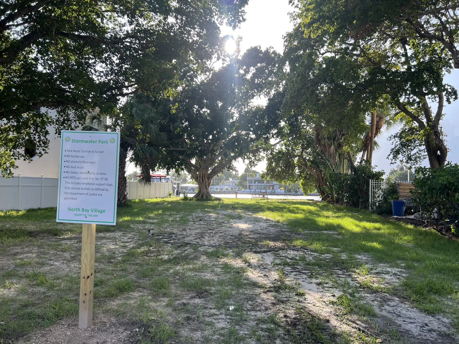 Large shade trees frame the bay beyond Stormwater Park’s entrance