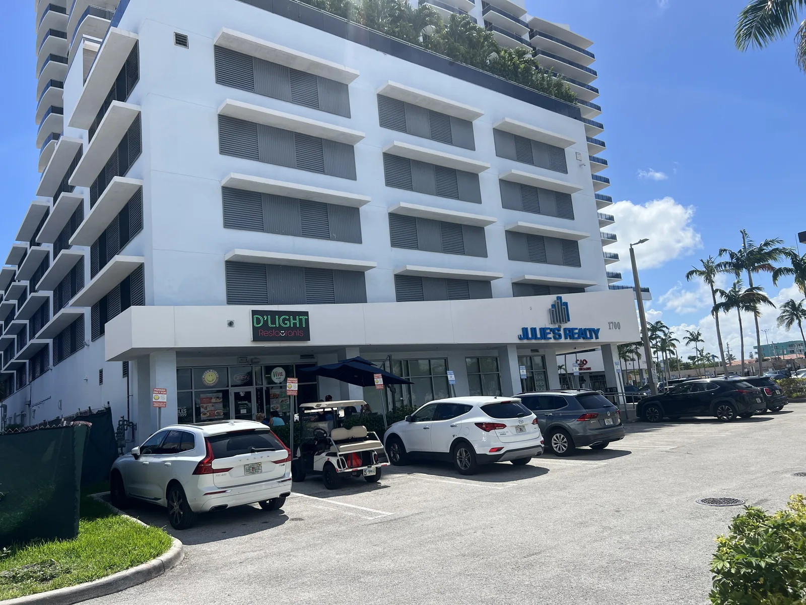 Street-level storefronts beneath the white residential building on Treasure Island.