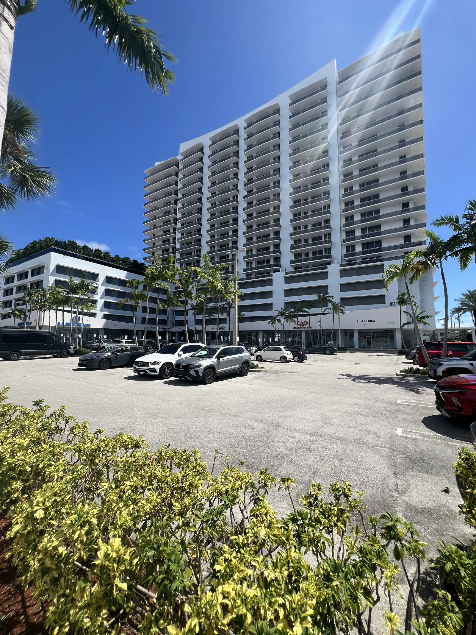 A white residential tower rises behind the parking area on Treasure Island.
